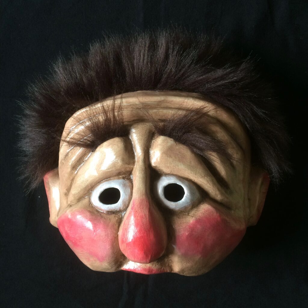 Demi-masque en papier mâché représentant un visage triste