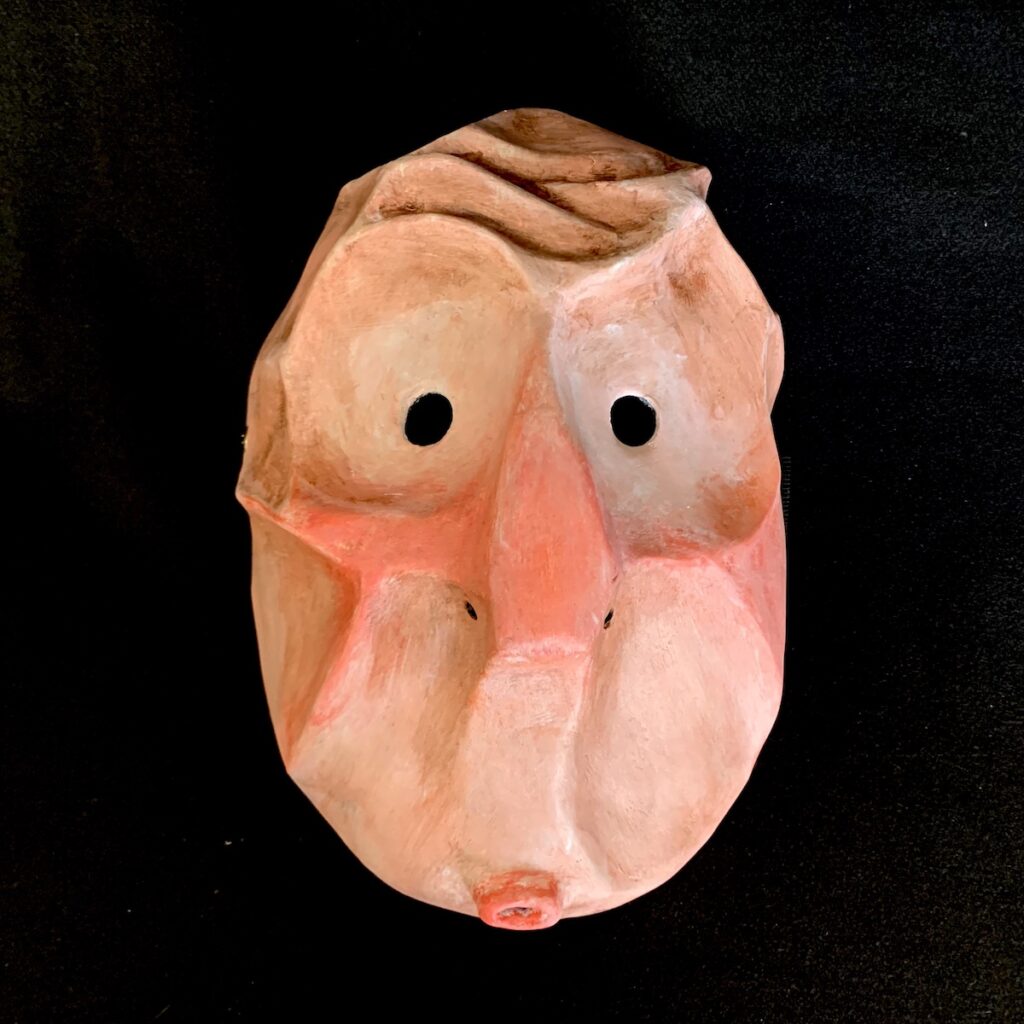 Masque représentant un visage expressif avec yeux ronds et petite bouche