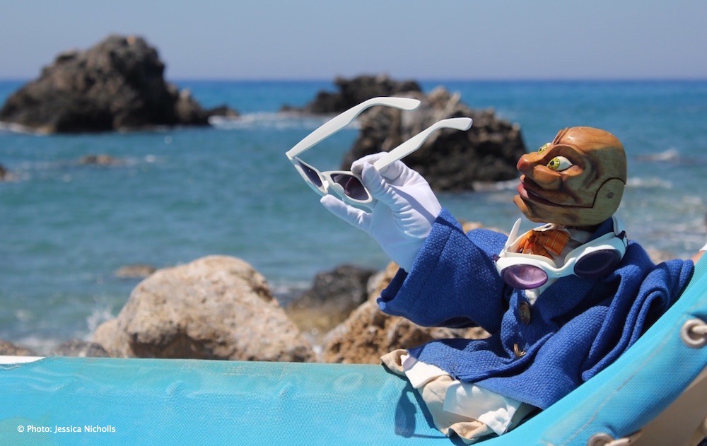 Igor in south of Crete on a sun chair next to the sea with white sunglasses in his hand