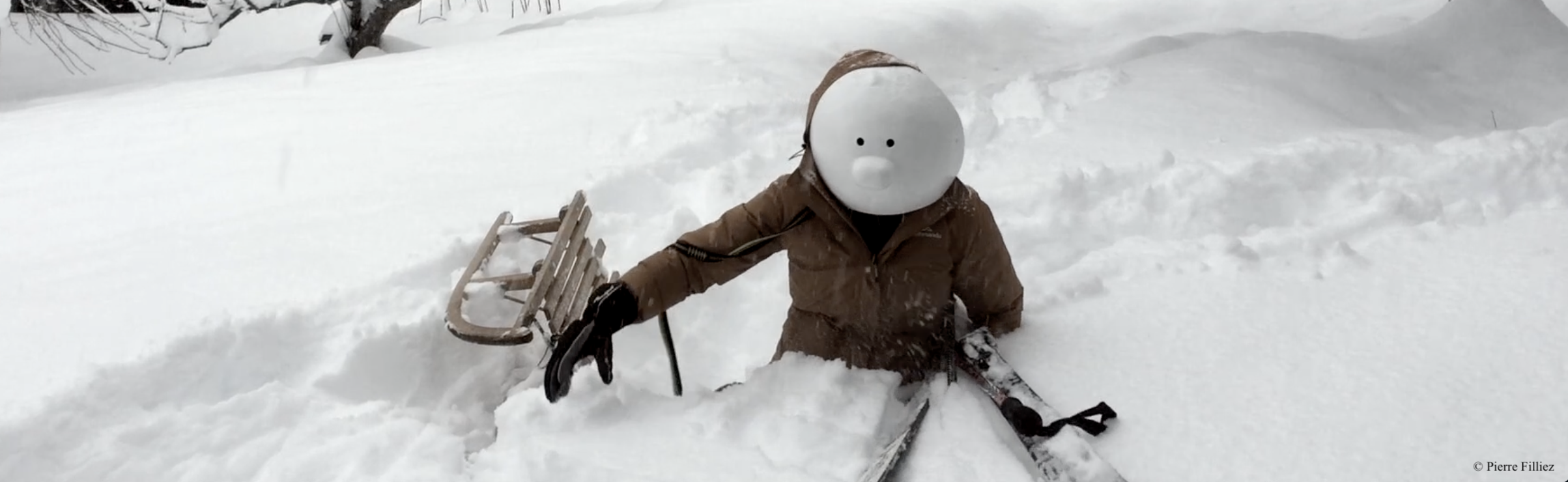Masque larvaire dans la neige avec luge et skis